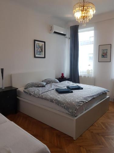 - une chambre avec un grand lit et un lustre dans l'établissement 12 Residence Cotroceni, à Bucarest