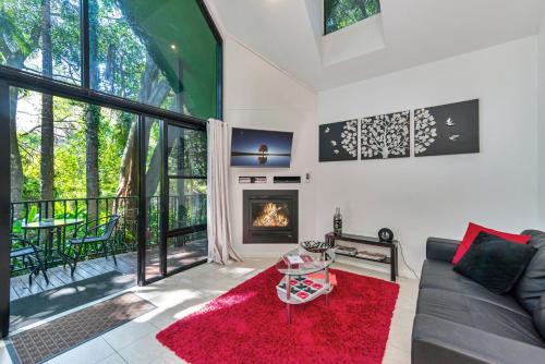 a living room filled with furniture and a fire place at Linger a While Chalet in Mount Tamborine