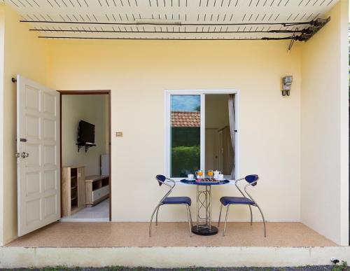 un patio con una mesa y 2 sillas y una puerta en 1 Bedroom + kitchen Rawaï en Rawai Beach