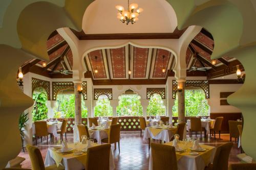 a restaurant with tables and chairs and a ceiling at Kuramathi Maldives in Rasdu