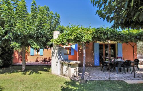 a house with a table and chairs in a yard at Cozy Home In Carpentras in Carpentras