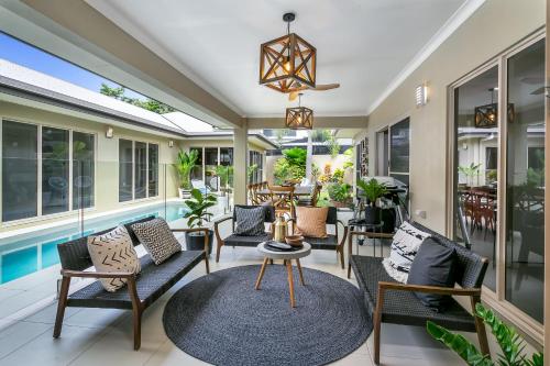 a patio with chairs and a table and a pool at Escapades @ Palm Cove in Palm Cove