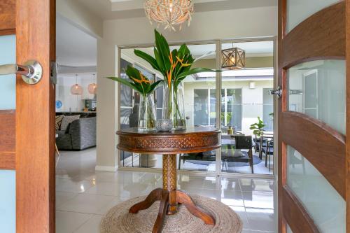 a vase of flowers on a table in a living room at Escapades @ Palm Cove in Palm Cove