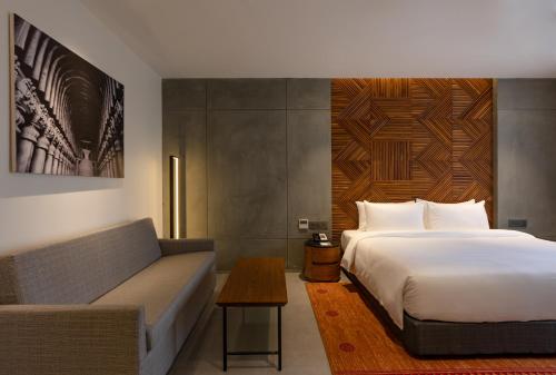 a hotel room with a bed and a couch at Radisson Resort and Spa Lonavala in Lonavala