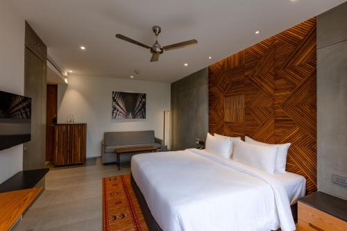 a bedroom with a large white bed and a couch at Radisson Resort and Spa Lonavala in Lonavala