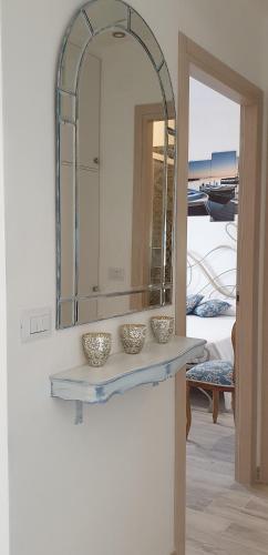 a mirror on a wall with two bowls on a shelf at Casa Paola in Rapallo
