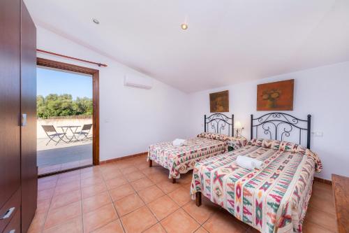 a bedroom with two beds and a balcony at Ses Angoixes in Santanyi
