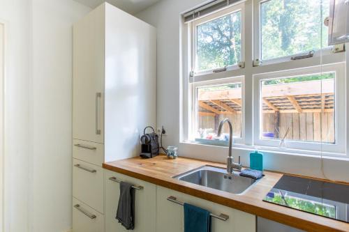 eine Küche mit einem Waschbecken und einem Fenster in der Unterkunft Koepel Enschede in Enschede