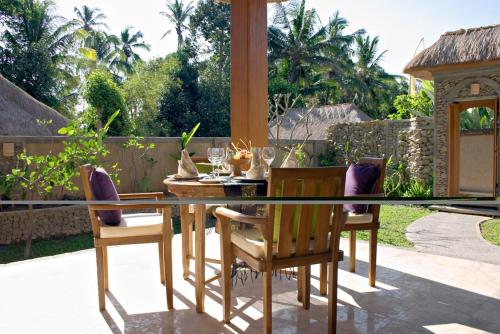 a dining table and chairs on a patio at Nefatari Exclusive Villas in Ubud