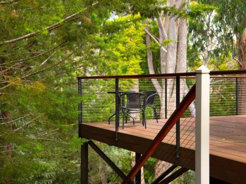 a deck with a chair sitting on top of it at Serena- a stone's throw from Lake Daylesford in Daylesford