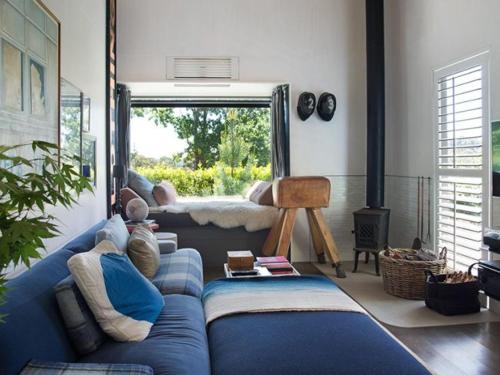 a living room with a blue couch and a window at Harts Lane Stag & Millies -stylish, pet friendly and views in Daylesford