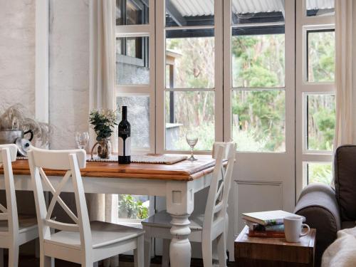 a dining room with a table and chairs and windows at Edessa Lodge in Glenlyon