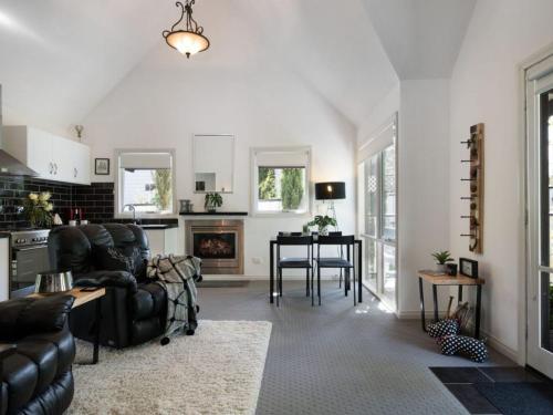 a living room with a couch and a table at Cottage 4A - sweet retreat with spa in Daylesford in Daylesford