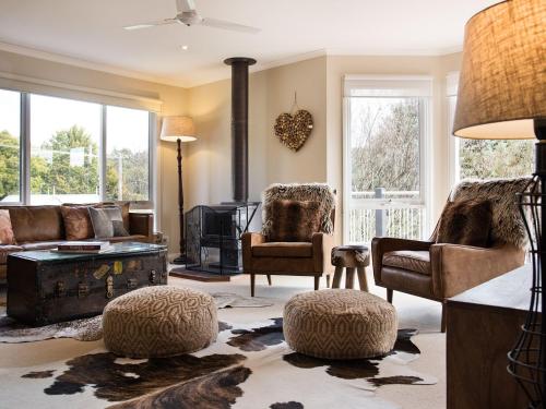 a living room with a couch and chairs and a fireplace at Accolade -3 bedroom, close to Lake Daylesford in Daylesford
