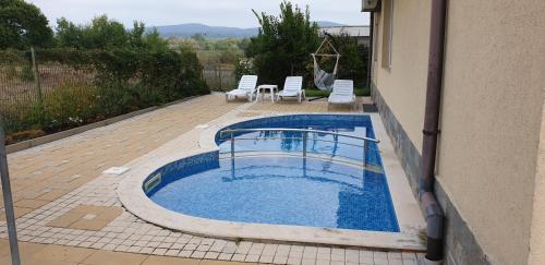 a small swimming pool with chairs and a building at Pearl Sunshine Appartments in Primorsko