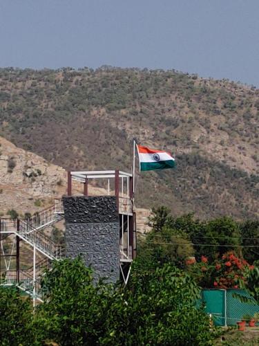a flag flying on top of a building with a mountain at Shivir Aranya - Wilderness Resort in Alwar