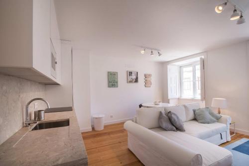 uma sala de estar branca com um sofá e uma mesa em Alfama Premium by Homing em Lisboa