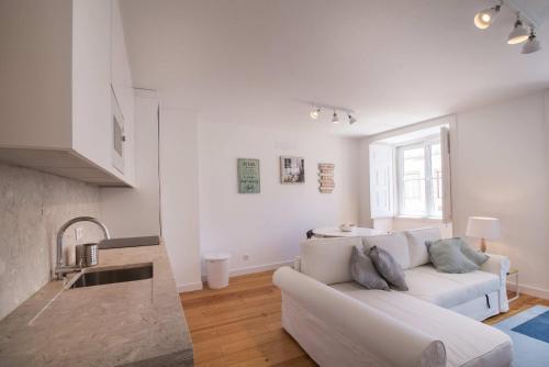 a white living room with a couch and a table at Alfama Premium by Homing in Lisbon