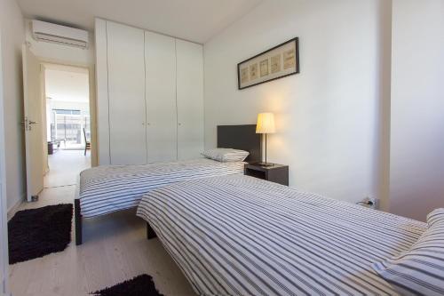 um quarto com 2 camas e um candeeiro em Expo Kid's Friendly by Homing em Sacavém