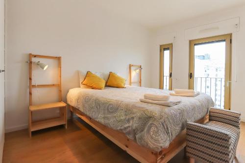 een slaapkamer met een bed met gele kussens erop bij Modern & Bright Avenidas Novas by Homing in Lissabon