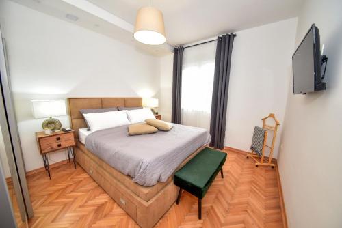 sypialnia z łóżkiem i telewizorem na ścianie w obiekcie Villa Teuta ZadarVillas w mieście Zadar