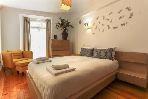 - une chambre avec un lit avec des oiseaux sur le mur dans l'établissement Grand Parliament Duplex by Homing, à Lisbonne