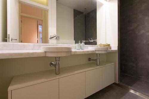 a bathroom with two sinks and a mirror at Downtown Prestige by Homing in Lisbon