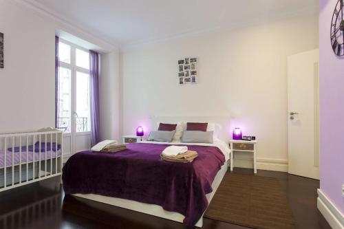 リスボンにあるDowntown Madalena by Homingの白いベッドルーム(紫のシーツを使用した大型ベッド1台付)
