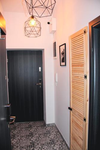 a hallway with a black door and a black and white floor at Apartament Kattowitz in Katowice