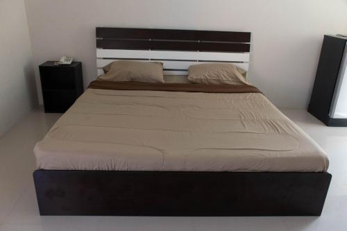 a large bed in a bedroom with a large headboard at Suree Place Hostel in Hua Hin