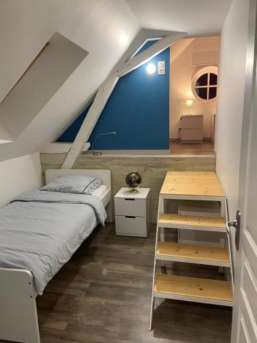 une chambre avec un lit et un mur bleu dans l'établissement Appartement du Château de la Caillerie, à Avoine