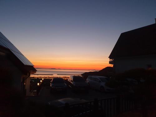 a sunset with cars parked in a parking lot at Herkules Namhae German Village in Namhae