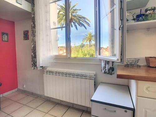 une cuisine avec une fenêtre et un palmier dans l'établissement Charmant appartement dans villa avec parc, à Cannes
