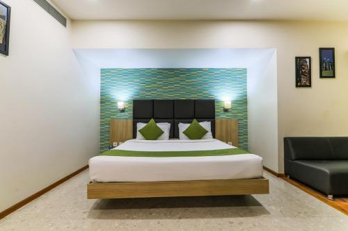a bedroom with a large bed and a couch at Magnus Star Residency in Pune