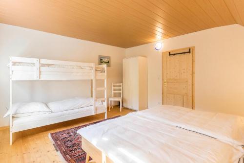 a bedroom with a white bed and bunk beds at Der Lachenbuckhof in Blumberg