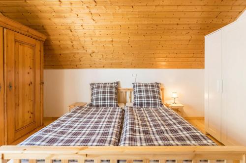 a bed in a room with a wooden ceiling at Der Lachenbuckhof in Blumberg