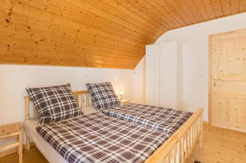 a twin bed in a room with a wooden ceiling at Der Lachenbuckhof in Blumberg