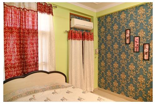 een slaapkamer met een bed met rood en groen behang bij Sohana's Homestays - Work Friendly Apartment near Jaipur International Airport in Jaipur