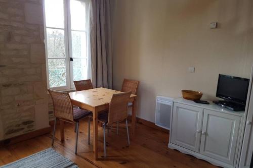 une salle à manger avec une table, des chaises et une télévision dans l'établissement Séjour à la campagne, à Placy