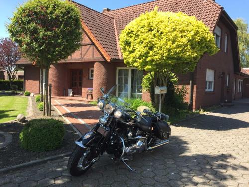 een motorfiets geparkeerd voor een huis bij Ferienwohnung Vereinswiek 95137 in Rhauderfehn