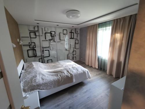 a bedroom with a white bed and a window at ALDO comfort in Ludza