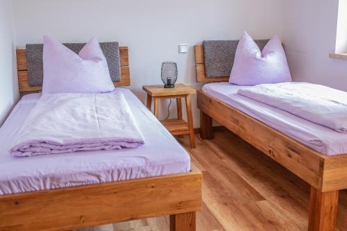 two beds in a room with purple pillows at Ferienhof Naderhirn - Bauernhof in Wegscheid