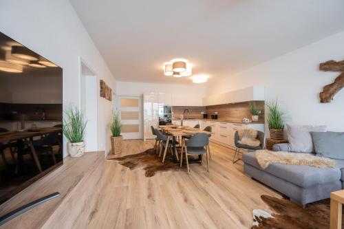 a living room and kitchen with a table and a couch at Apartmány Kaskády Luhačovice in Luhačovice