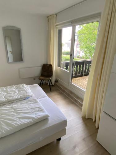 a bedroom with a bed and a window with a balcony at Ferienwohnung Fichtenweg in Winterberg