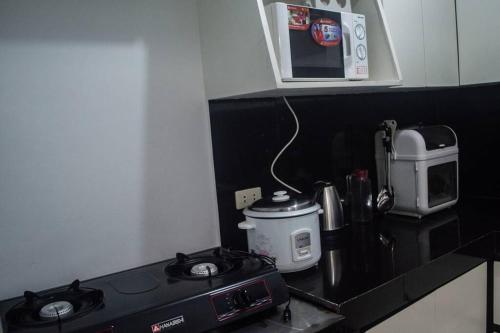 a kitchen counter with a stove and a microwave at Jan's Haven Staycation House Deca Clark Angeles in Angeles