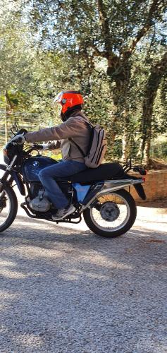 a man riding a motorcycle down the road at Orto degli Ulivi in Sinalunga