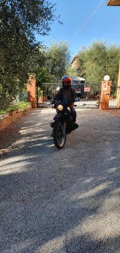 a person riding a motorcycle down a street at Orto degli Ulivi in Sinalunga