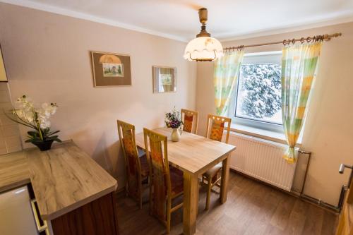 a dining room with a wooden table and chairs at Chalupa Háj in Jindřichovice