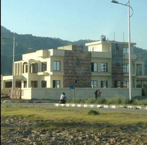 un gran edificio blanco con dos personas caminando delante de él en Sarai Silk Route, en Islamabad