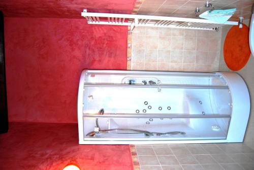 a bath tub in a bathroom with a red wall at Tenuta Fortelongo in Fara Vicentino